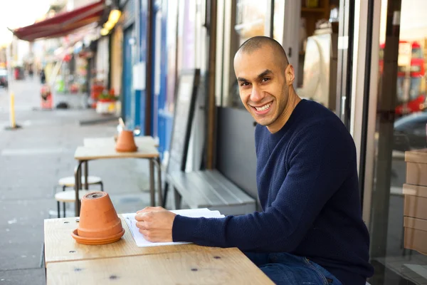 Hombre sentado fuera de una cafetería — Foto de Stock