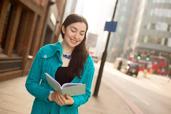 Young woman reading a notebook — Stock Photo, Image
