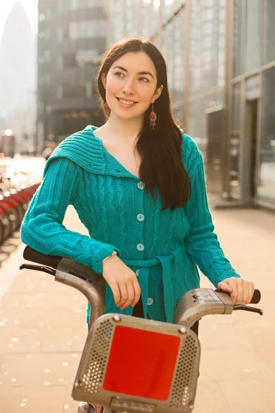 Mujer joven con una bicicleta de alquiler — Foto de Stock