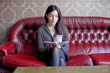 genç kadın bir içkiyle okuma