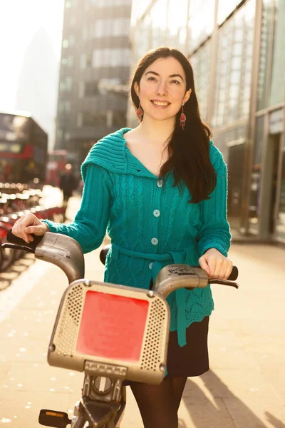 Mujer joven con una bicicleta de alquiler — Foto de Stock