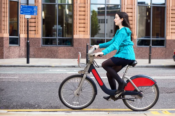 Mujer joven montando una bicicleta de alquiler —  Fotos de Stock