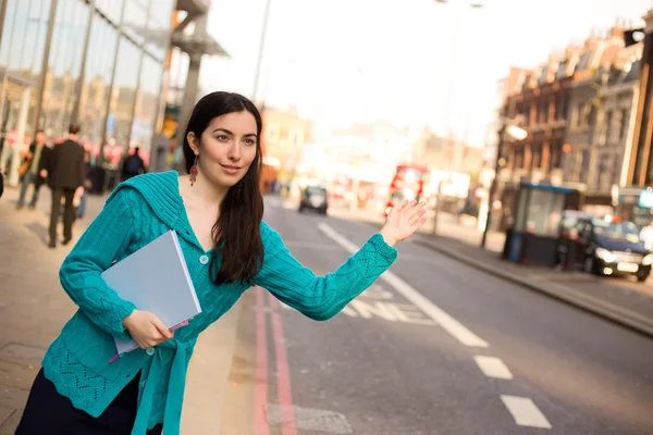 Young woman hailing a taxi — Stock Photo, Image