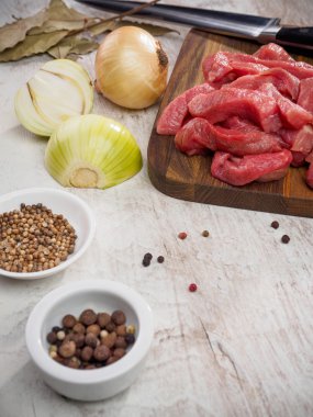 çiğ et dilimleri kesme tahtası biber ve soğan ile