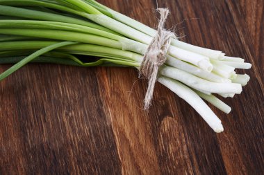 koyu ahşap üzerine taze soğan