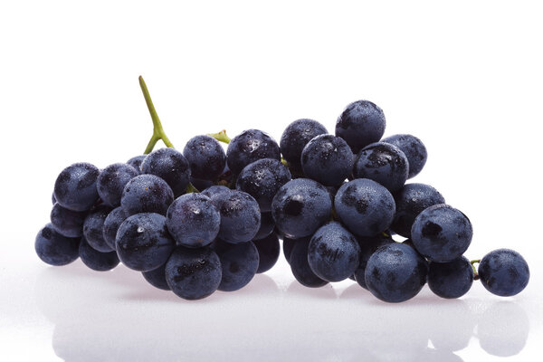 Свежий виноград на белом с капельками воды
