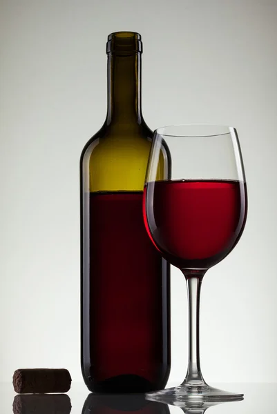 Вино в стакане и бутылка на белом — стоковое фото