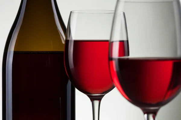 Вино в стакане и бутылка вина на белом — стоковое фото
