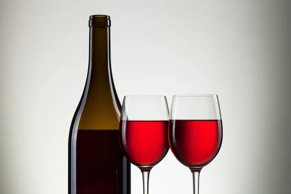 Wijn in glazen en een fles wijn op wit — Stockfoto