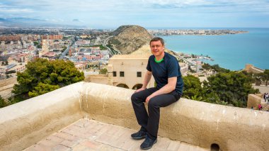 Olgun bir adam güneşli bir günde deniz kıyısında dinleniyor.