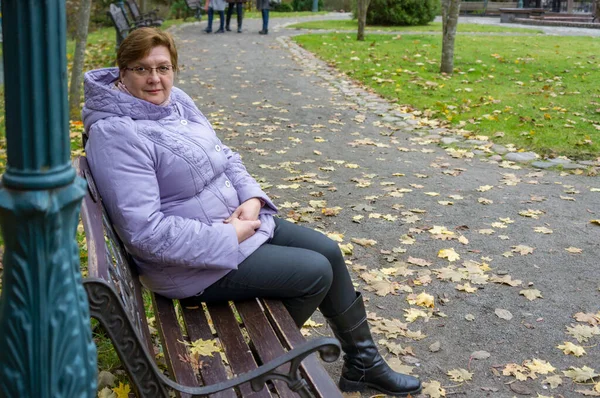 Volwassen Mollige Vrouw Bril Blauwe Jas Rusten Een Stad Park — Stockfoto