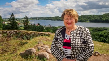 Olgun tombul kadın eski şehrin sokaklarında yürüyor. Nehrin kenarındaki setin üzerinde duruyor..