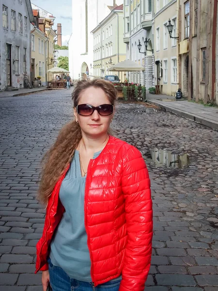 Kırmızılı Neşeli Genç Bir Kadın Eski Şehrin Sokaklarında Yürüyor Fotoğrafçıya — Stok fotoğraf