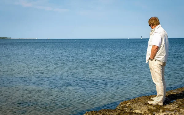 祖父は夏の日にバルト海の堤防に沿って歩きます — ストック写真