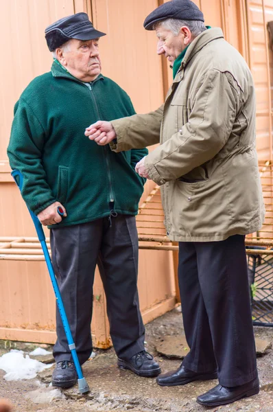 Two aged men discuss in the street — Stock Photo, Image