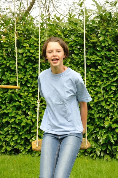 A girl playing in a swing — Stock Photo, Image