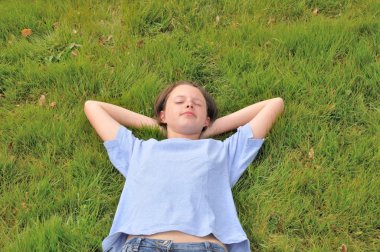 Kız çimenlerin üzerinde uyuyor