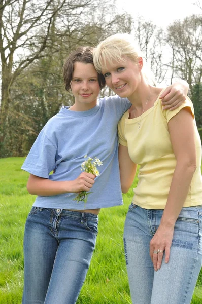 Hija ofreciendo flores a su madre — Foto de Stock