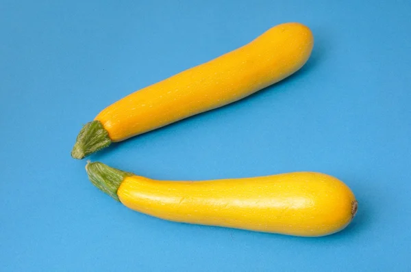 Yellow courgettes on a blue background — Stock Photo, Image