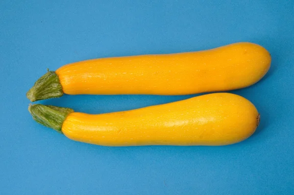 Yellow courgettes on a blue background — Stock Photo, Image