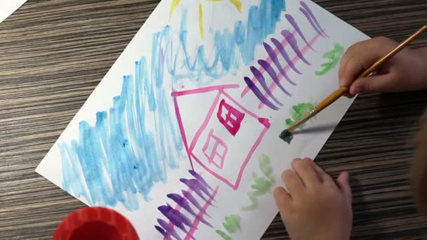 Kinderhand mit Pinseln Zeichnung auf weißem Papier Draufsicht — Stockvideo