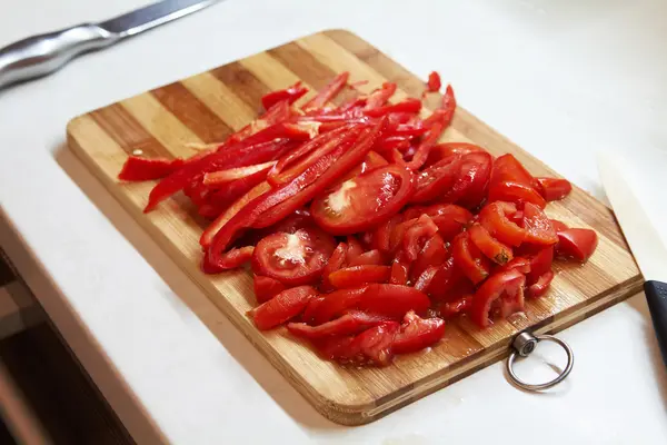 Gehackte rote Paprika auf einem Holzschneidebrett. — Stockfoto