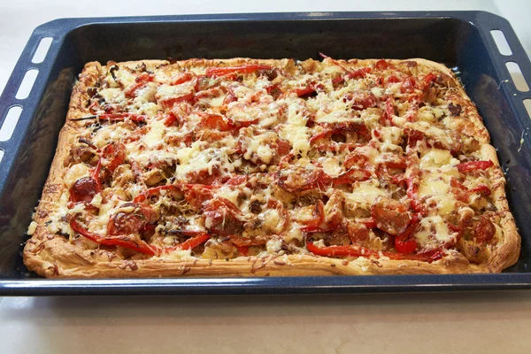 Pizza rectangular siciliana con queso y tomate en bandeja para hornear Imagen de stock