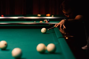 Bilardo oyuncusu topa ateş ediyor.