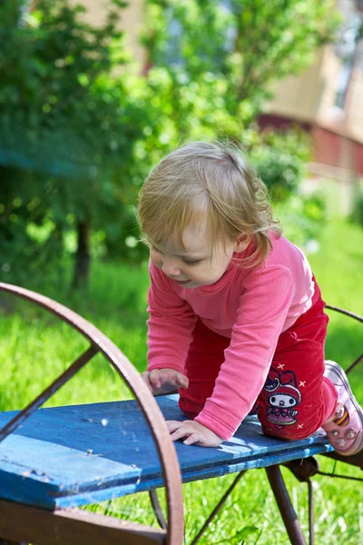 Little girl on the bench in park — Stock Photo, Image