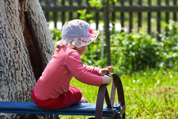 Little girl on the bench in park — Stock Photo, Image