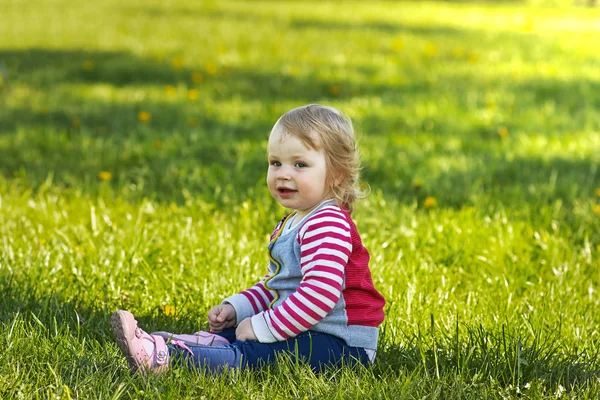 Girl in park sitting on the green grass — Stock Photo, Image