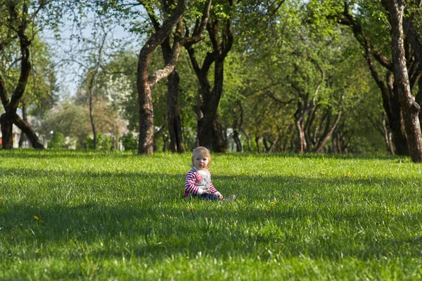 Girl in park sitting on the green grass — Stock Photo, Image