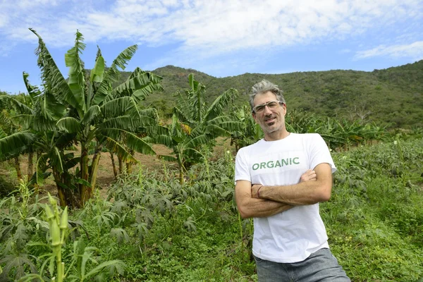 Organic farmer in front of farmland — Stock Photo, Image