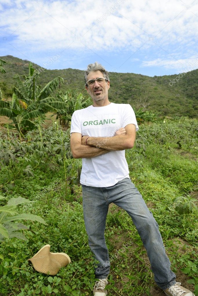 Organic farmer in front of farmland