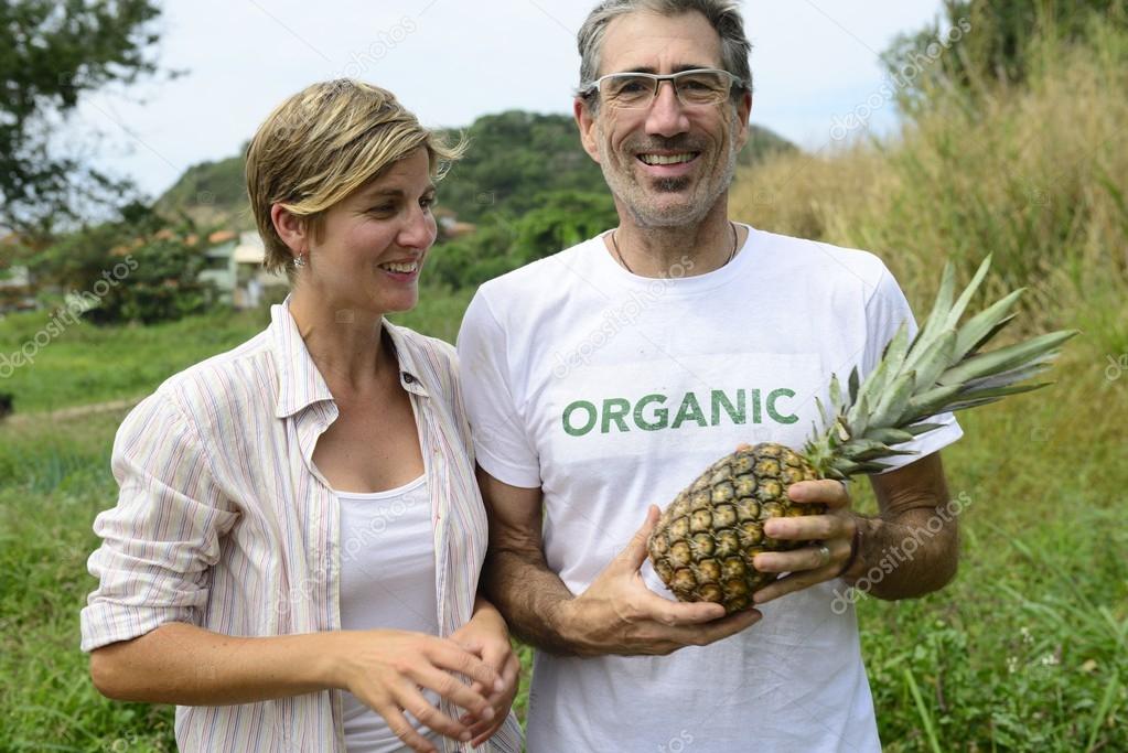 Farmer couple showing pineapple