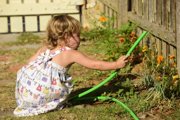 Ragazzo che annaffia fiori in giardino — Foto Stock