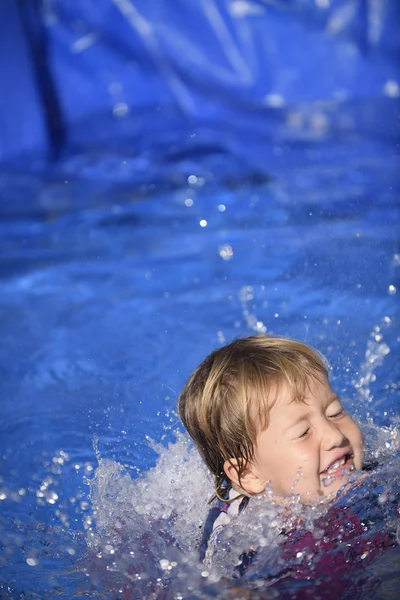 Baby girl splashing in swimming pool — Stock Photo, Image