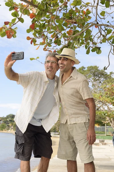 Bögpar som tar en selfie med mobiltelefon Stockbild