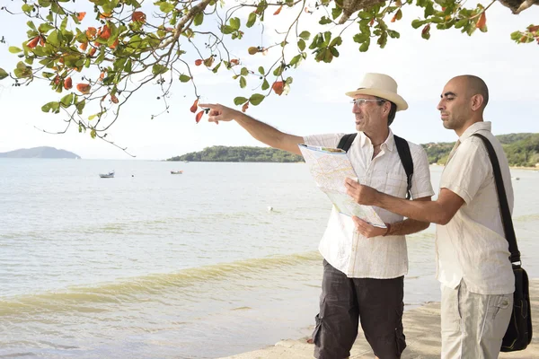 Schwules Paar im Urlaub zeigt auf Reiseziel Stockfoto