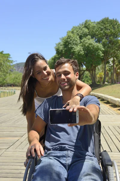 Man i rullstol och flickvän tar en selfie — Stockfoto