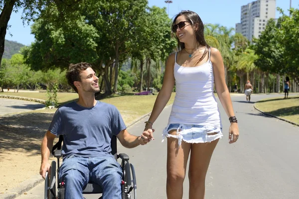 Muž na vozíku a přítelkyně — Stock fotografie