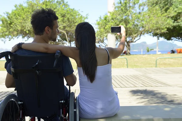 Homme en fauteuil roulant et petite amie — Photo