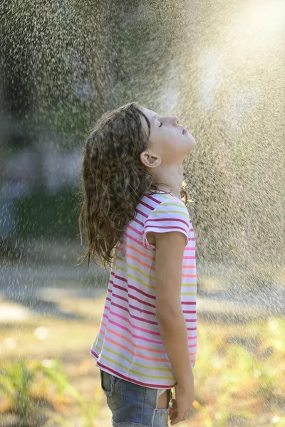 Девушка наслаждается легким летним дождем . Стоковое Изображение