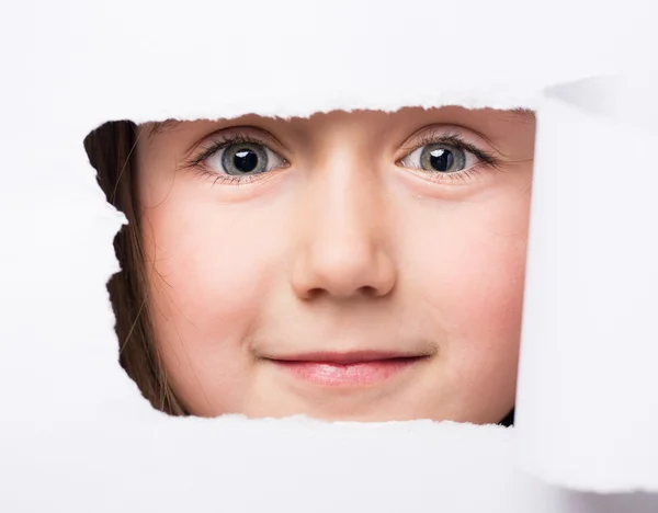 Ritratto di una ragazza attraverso un buco in una carta — Foto Stock