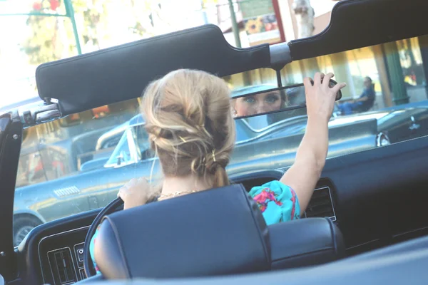 Mujer encantadora posando y y alrededor de un coche vintage — Foto de Stock