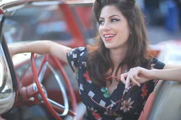 Linda mulher posando e e em torno de um carro vintage — Fotografia de Stock