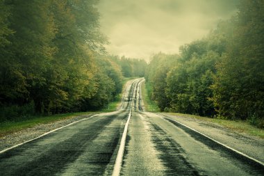 Bir fırtına gökyüzü altında karanlık asfalt yolu