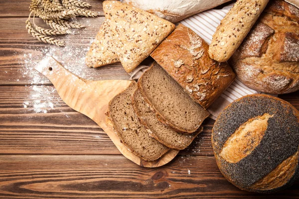 Sortimento de pão na superfície de madeira — Fotografia de Stock