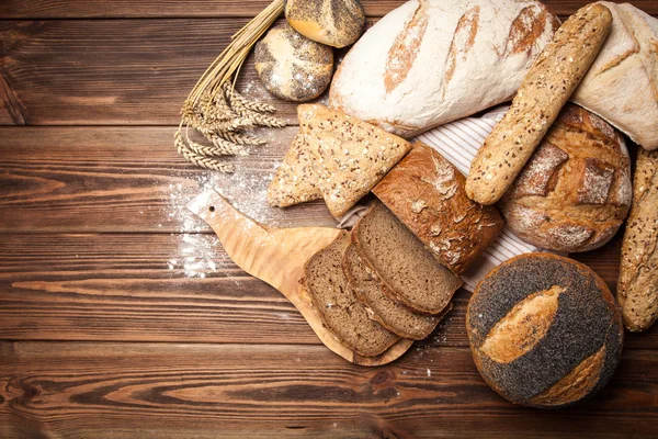 Ποικιλία ψωμιού στην ξύλινη επιφάνεια — Φωτογραφία Αρχείου