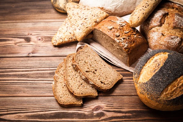 Bread assortment on wooden surface — Stock Photo, Image